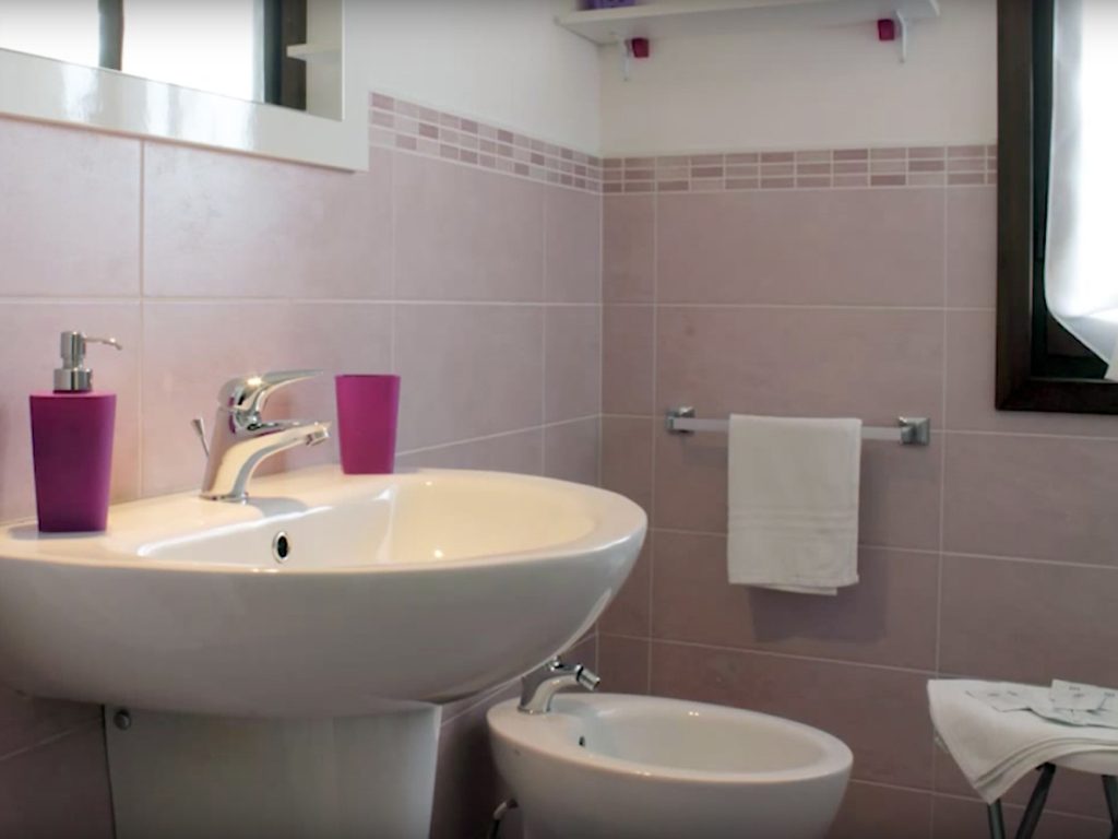 Bagno della camera Ciclamino con doccia e piastrelle rosa