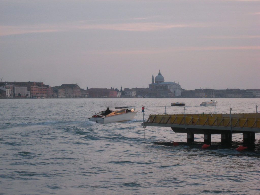 La laguna di Venezia al tramonto con una barca e la città sullo sfondo