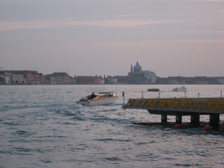 La laguna di Venezia al tramonto con una barca e la città sullo sfondo