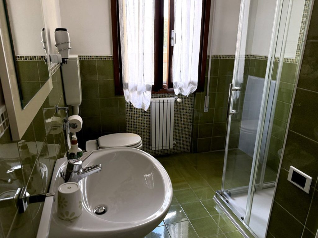 Bagno della camera Felci, piastrelle verdi e box doccia