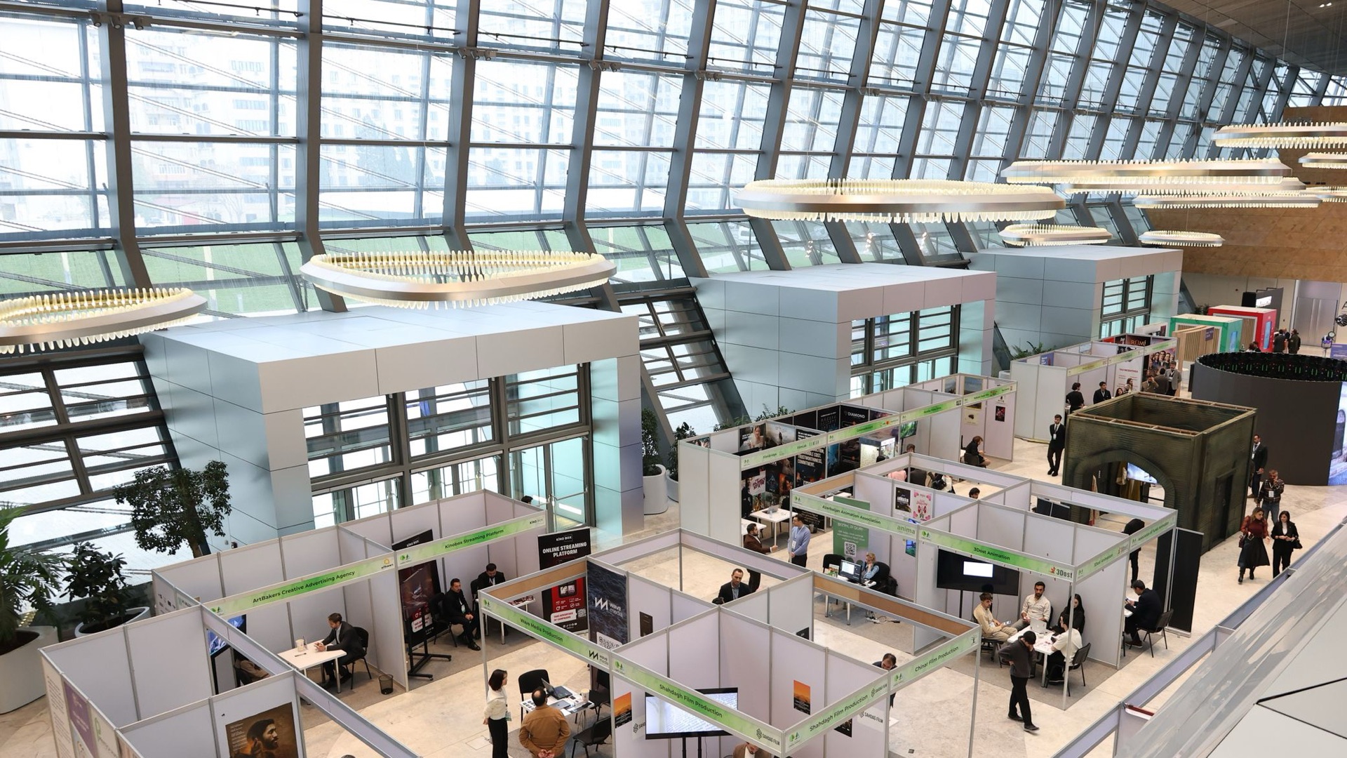 Padiglione fieristico con stand e visitatori, visto dall'alto