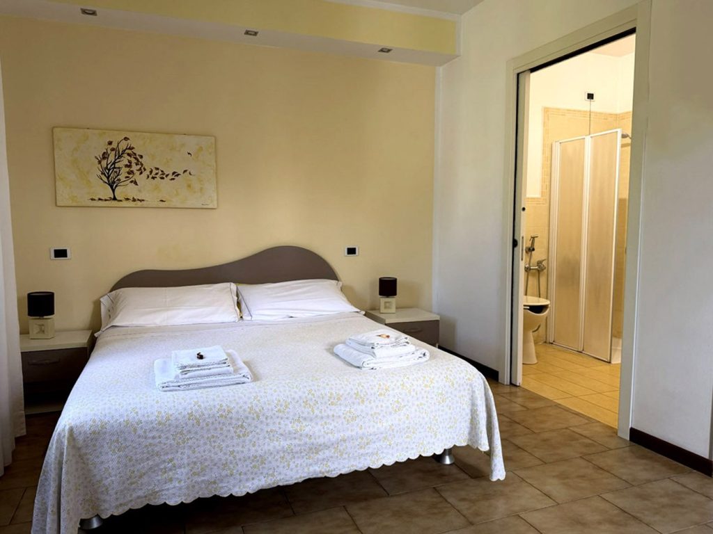 Camera Foglie d'autunno, letto matrimoniale con il bagno privato sullo sfondo