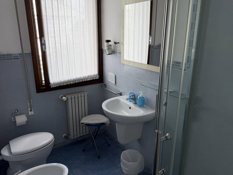 Bagno della camera Genziana, piastrelle azzurre e box doccia